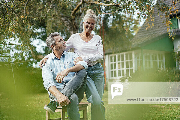 Lächelnde Frau steht neben Mann im Hinterhof