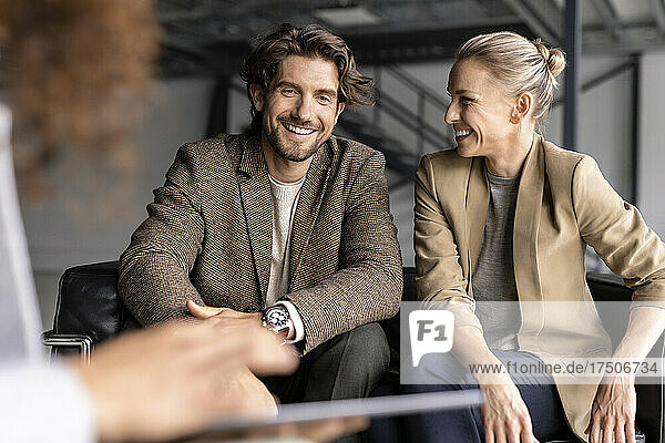 Smiling businessman and colleague discussing in industrial hall