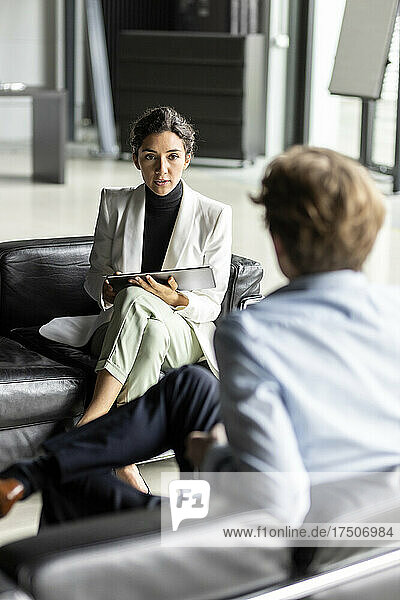 Businesswoman discussing with businessman in lobby