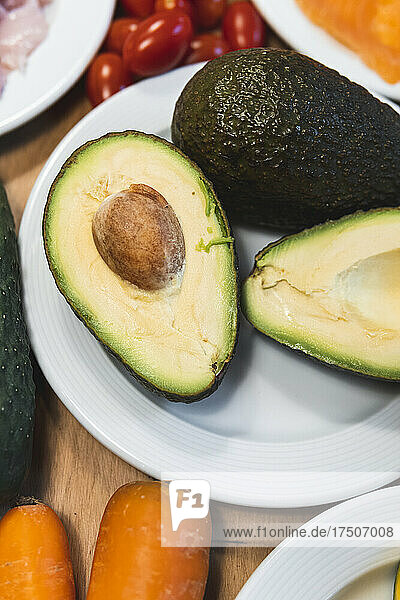 Halved avocados on plate on table