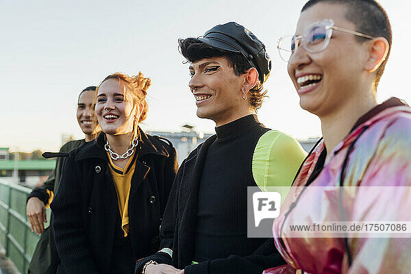 Smiling gay man with friends at sunset