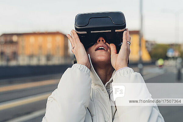 Young woman with virtual reality headset at street