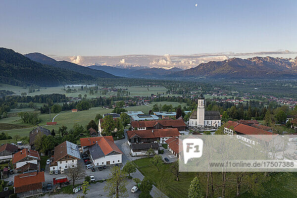 Germany  Bavaria  Gaissach  Drone view of mountain village at dawn with Benediktenwand and Brauneck in background