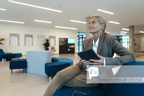 Businesswoman with tablet PC at office lobby