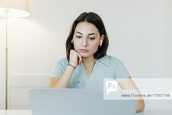 Young female freelancer working on laptop at home office