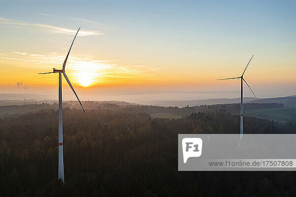 Aerial view of wind farm in forested Schurwald range at sunset