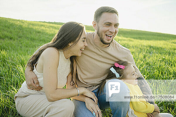 Playful couple enjoying with daughter on grass