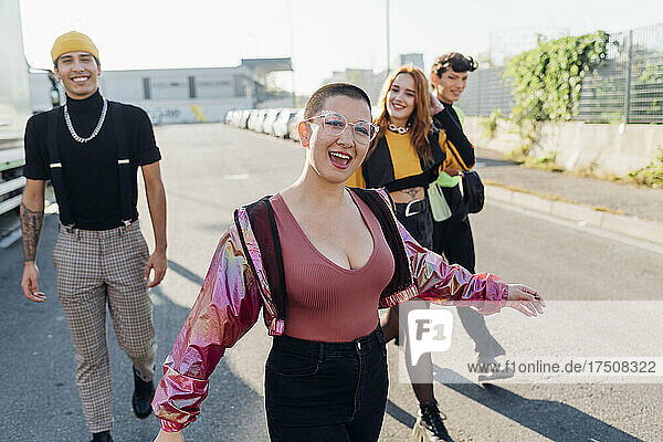 Happy woman walking with friends in background on road