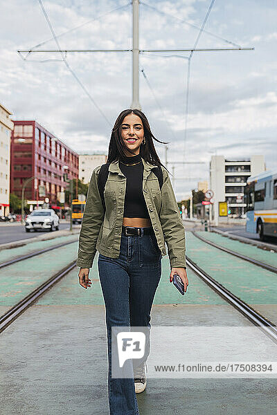 Young woman walking on tram tracks