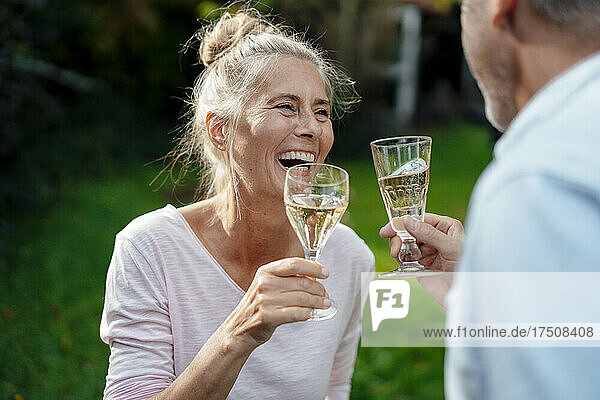 Smiling woman having champagne with man at backyard