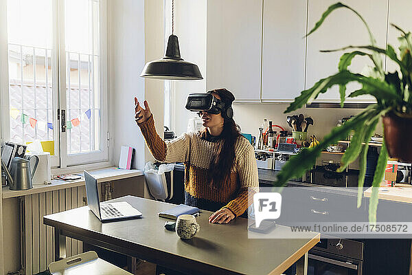 Woman gesturing wearing virtual reality headset at home