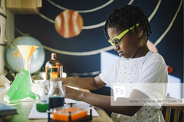 Studentin konzentriert sich bei einem wissenschaftlichen Projekt am Tisch