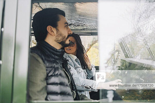 Frau sitzt mit männlichem Freund in einem Geländewagen