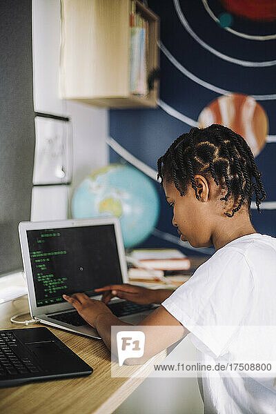 Motiviertes Mädchen lernt zu Hause am Laptop Programmieren