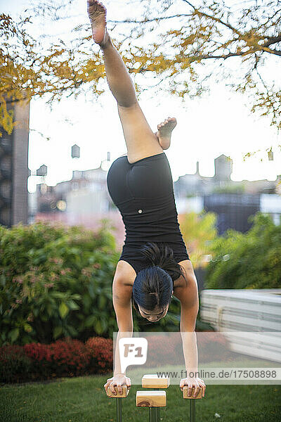 Female gymnast performing handstand outdoors