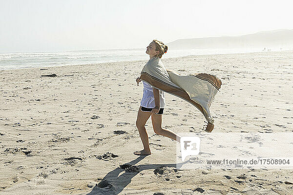 Teenage girl dancing on a sandy beach