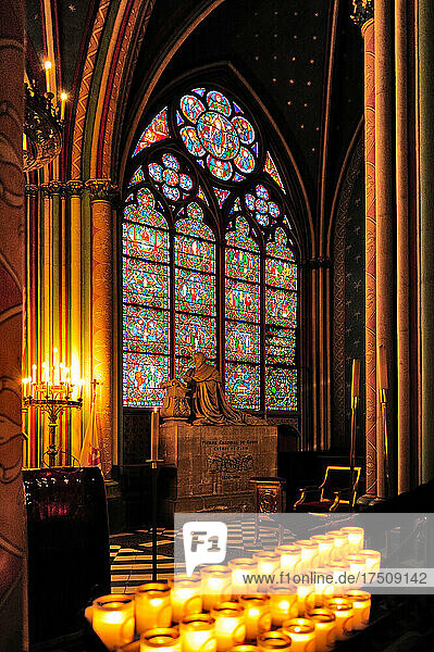 Das Innere der Kathedrale Notre Dame in Paris vor dem Brand 2019  ein Buntglasfenster und Reihen von brennenden Kerzen