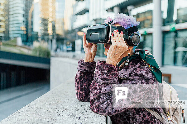 Italy  Fashionable senior woman withVRgoggles in city