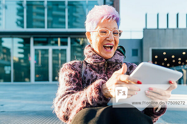 Italy  Fashionable senior woman using tablet in city