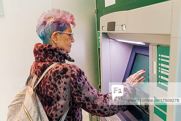 Italy  Fashionable senior woman at ATM in city