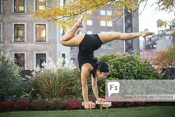 Female gymnast performing handstand outdoors