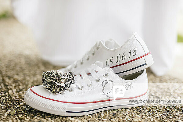 Close-up of bride shoes with text and antique ring on footpath