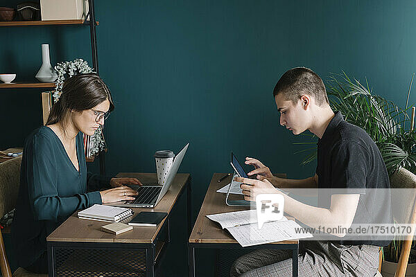 Young man and woman working on desks at home