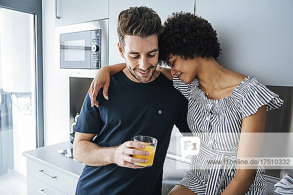 Romantic multi-ethnic couple in kitchen of penthouse
