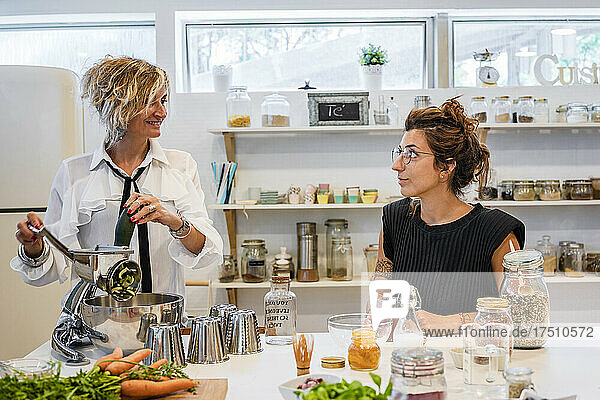 Female chef using food processor while teaching at cooking class