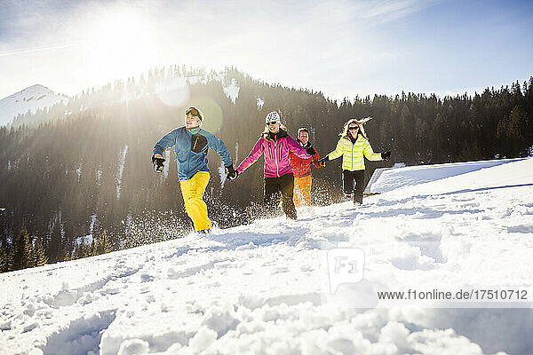 Group of carefree friends running and having fun in snow  Achenkirch  Austria