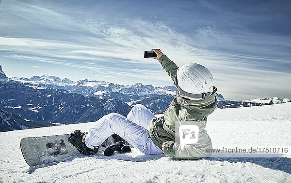 Snowboarderin macht ein Selfie im Schnee