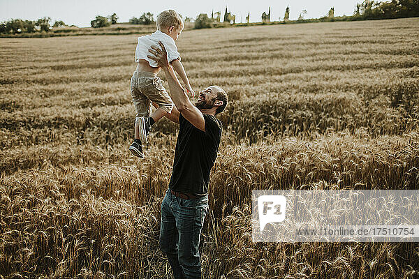Father spending leisure time with son in wheat farm