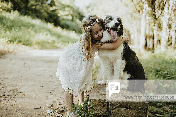 Girl embracing Border Collie in nature