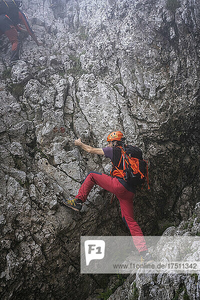 Reifer Mann mit Rucksack beim Klettern auf einem Berg  Bergamasker Alpen  Italien