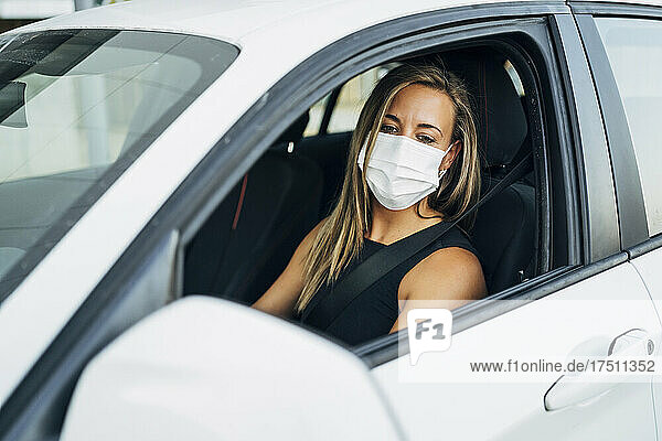 Woman in car with protective mask