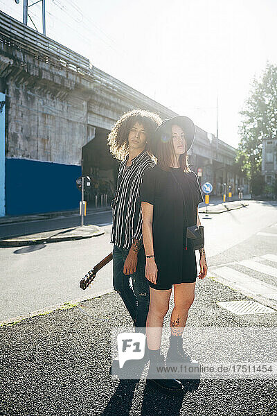 Paar steht an sonnigen Tagen auf der Straße vor klarem Himmel