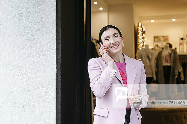 Stylish woman in pink jacket using talking on the