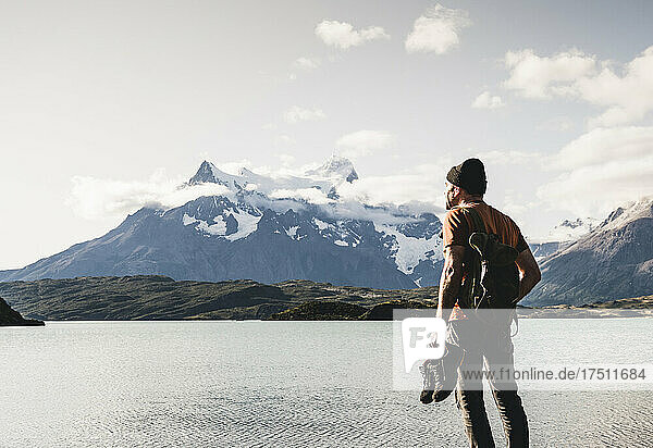 Man with shoes admiring view of lake Pehoe in Torres Del Paine National Park  Chile Patagonia  South America