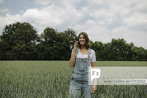Young woman on the phone in a grain field in the countryside