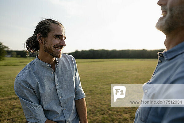 Happy adult son with father on a meadow in the countryside