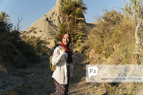 Smiling young tourist woman wearing Hijab on a hiking trip