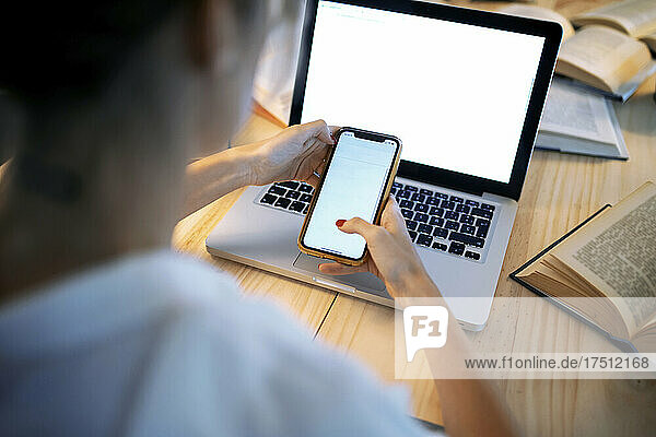 Businesswoman using phone at home office