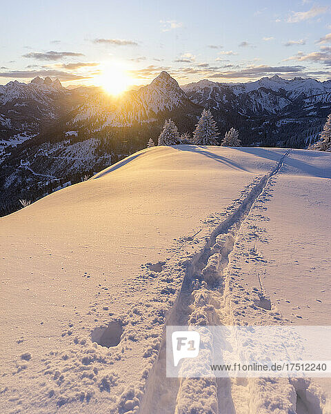 Ski tracks on snowcapped peak of Schonkahler mountain at sunrise