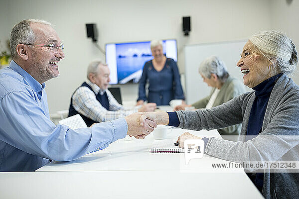 Senior citizens meeting at skill enhencement course  shaking hands