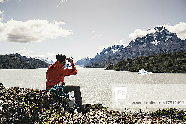 Man looking at Grey Glacier with binocular at Torres Del Paine National Park  Patagonia  Chile  South America