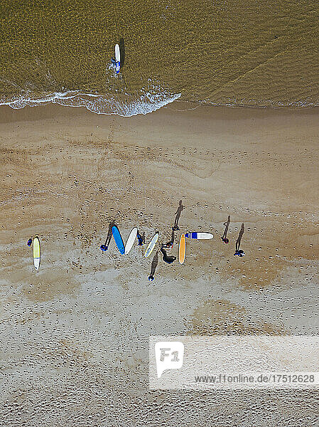 Aerial view of surfers preparing at sandy coastal beach