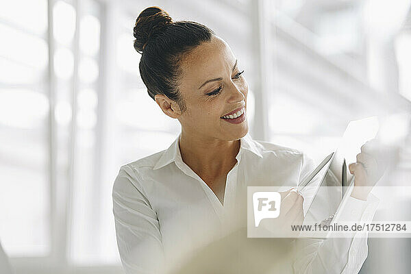 Close-up of smiling businesswoman using digital tablet in home office