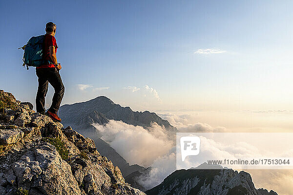 Man admiring view while standing on mountain peak at Bergamasque Alps  Italy