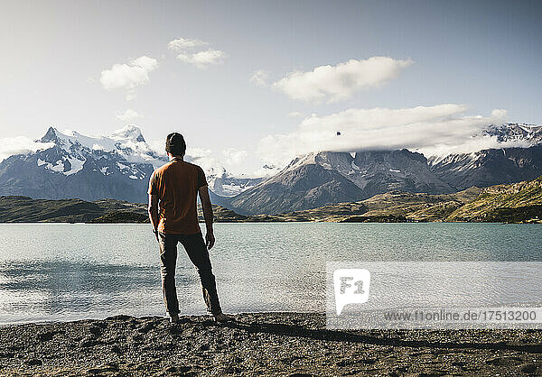Man standing and looking at view of Lake Pehoe in Torres Del Paine National Park Patagonia  South America