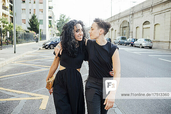 Smiling lesbian couple walking in city